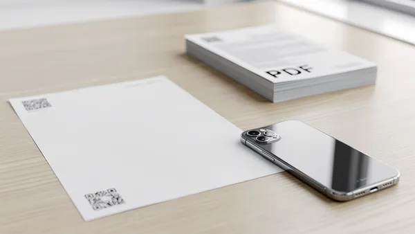 Printed document with QR code linking to a PDF file on a desk
