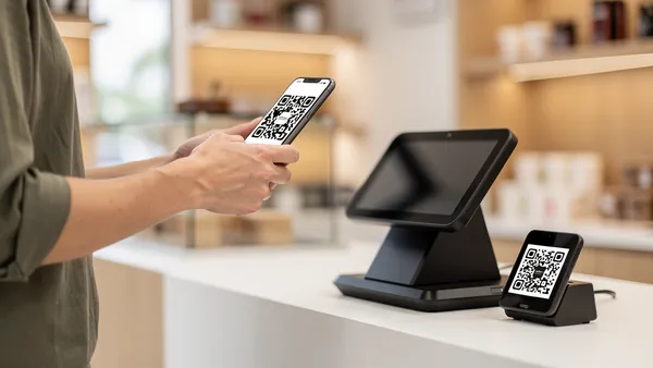 Customer scanning a QR code at a point-of-sale terminal to pay