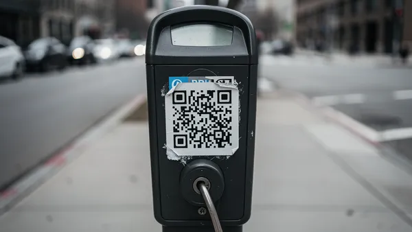 Suspicious QR code sticker placed over an original code on a parking meter