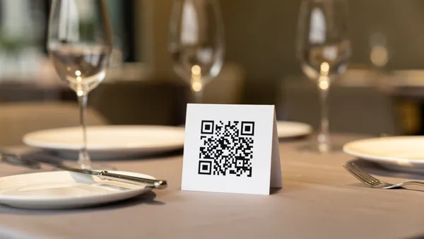 Restaurant table with QR code menu card alongside place settings
